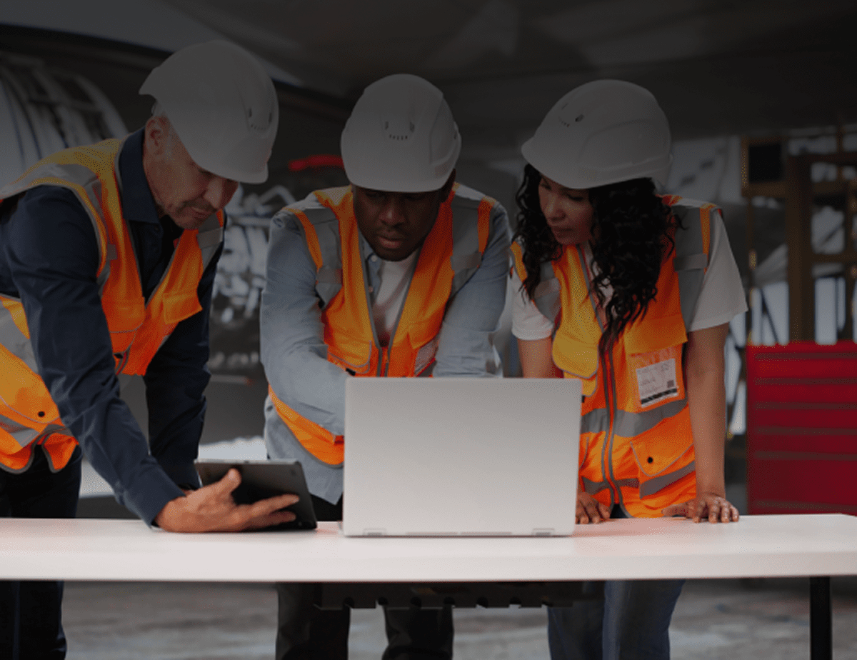 Construction team reviewing plans on laptop